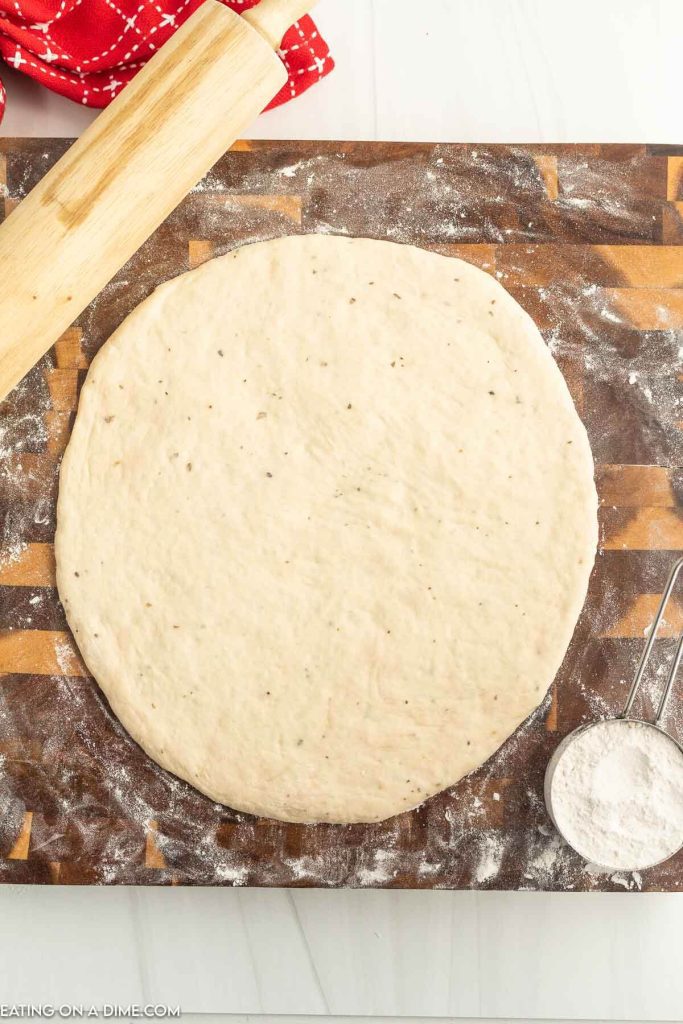 Homemade pizza crust on a floured surface