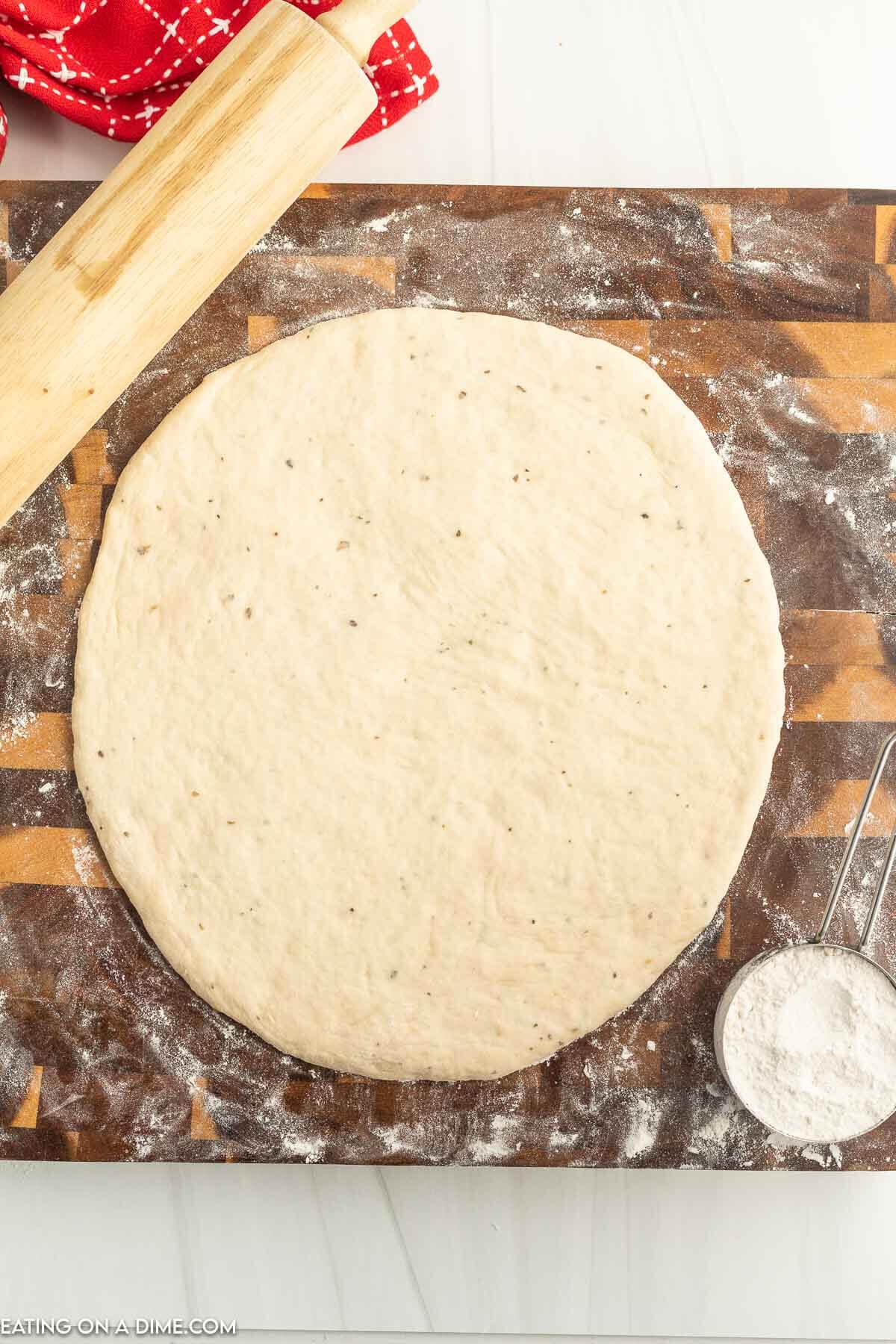 Pizza Dough spread on a floured wooden surface