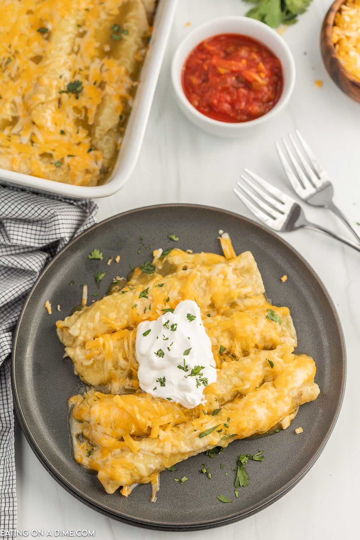 Taquito Enchiladas on a plate topped with sour cream