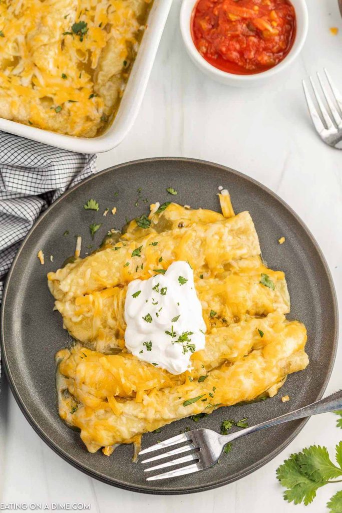 Taquito Enchiladas on a plate topped with sour cream