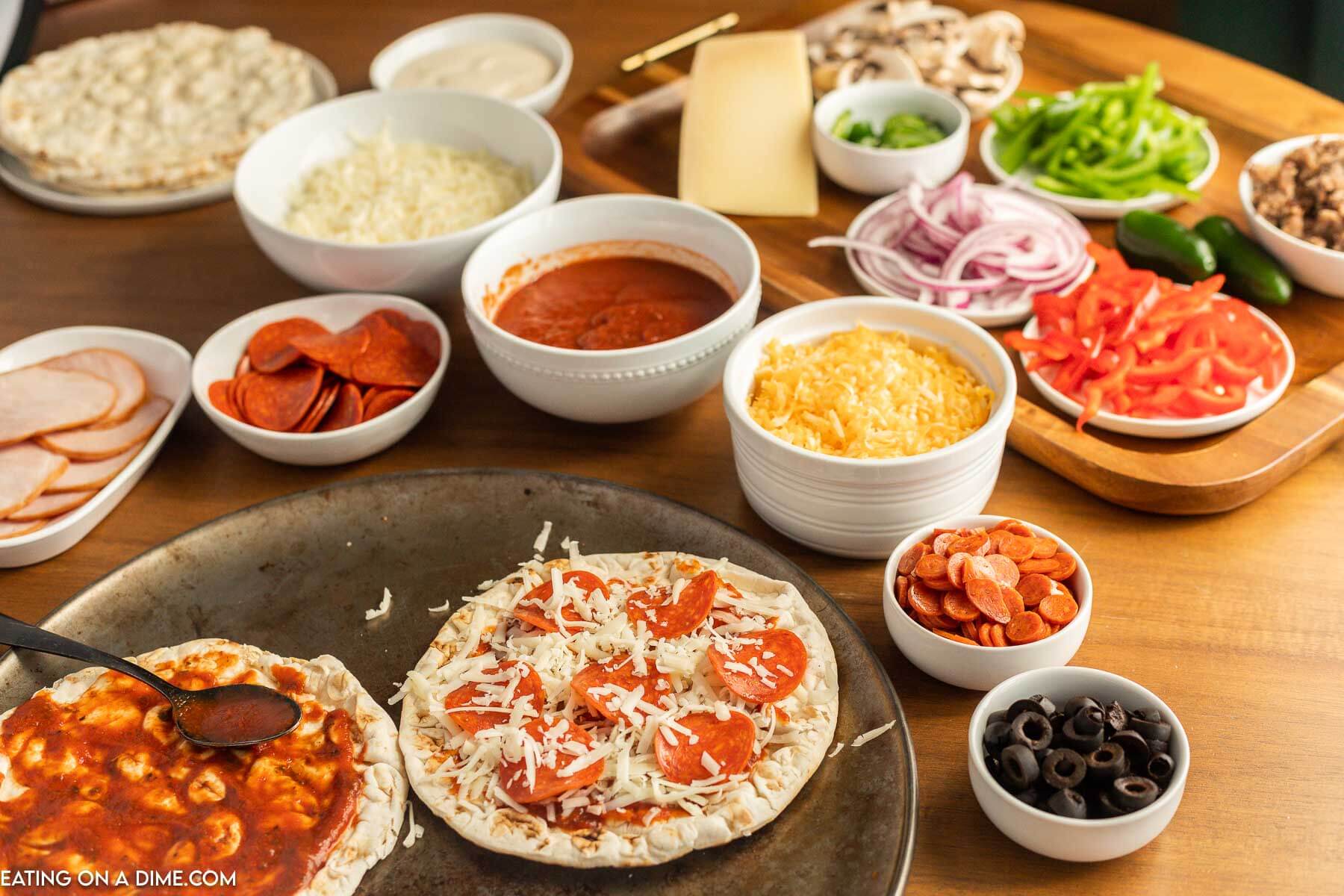 Adding sauce and pizza toppings to flatbreads