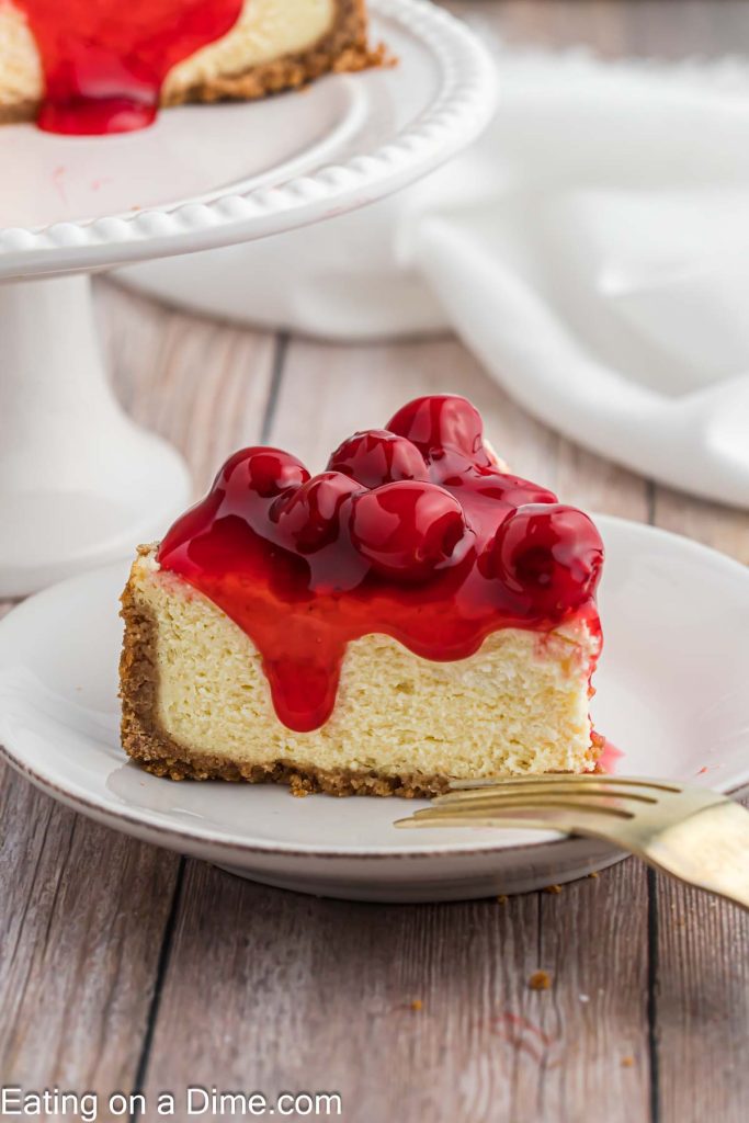 A slice of cheesecake on a plate topped with cherry