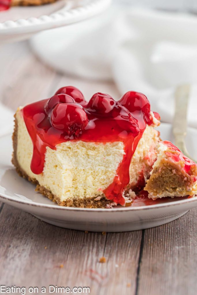 A slice of cherry topped cheesecake on a plate