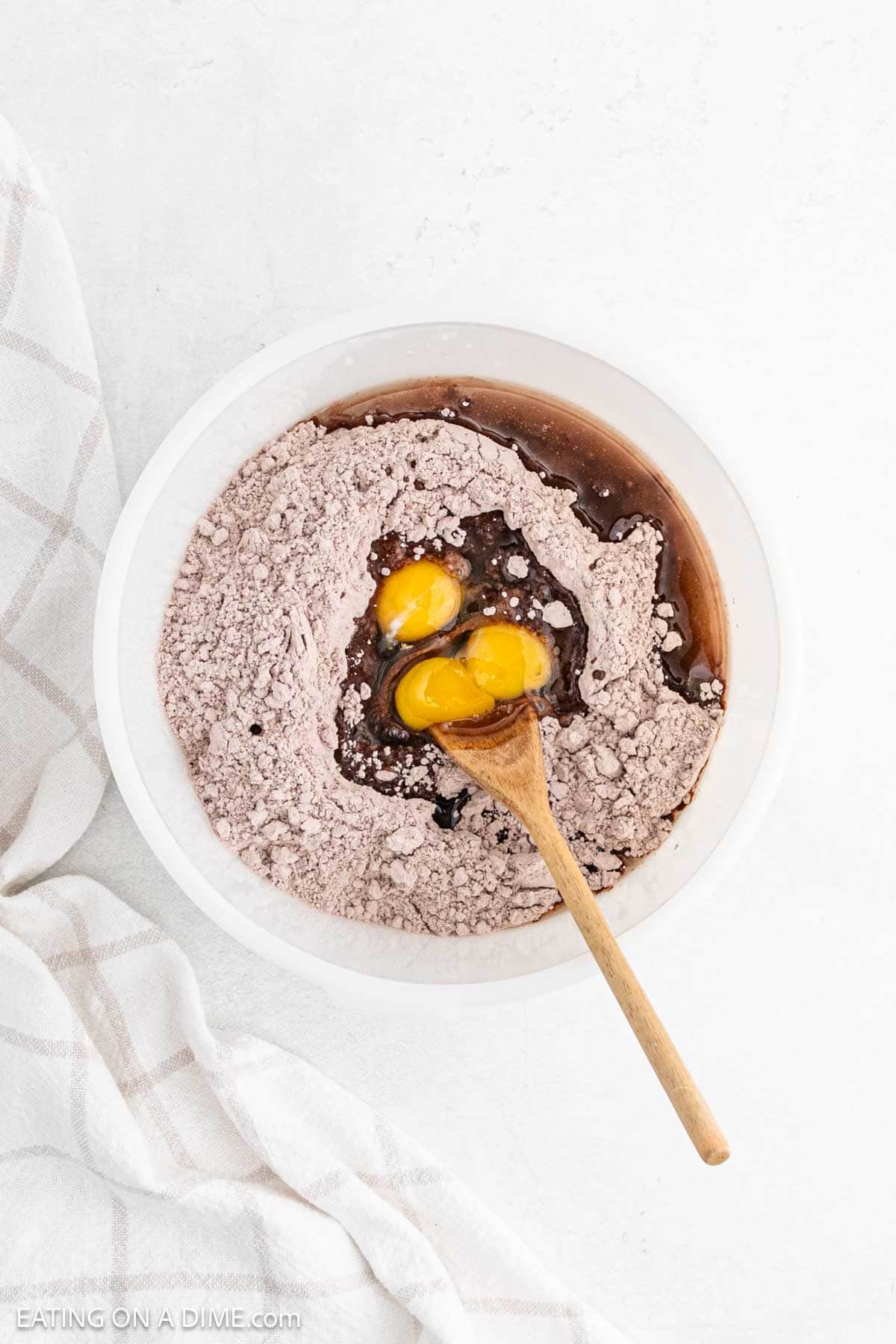 Brownie Mix in a bowl mixed with the eggs and oil with a wooden spoon