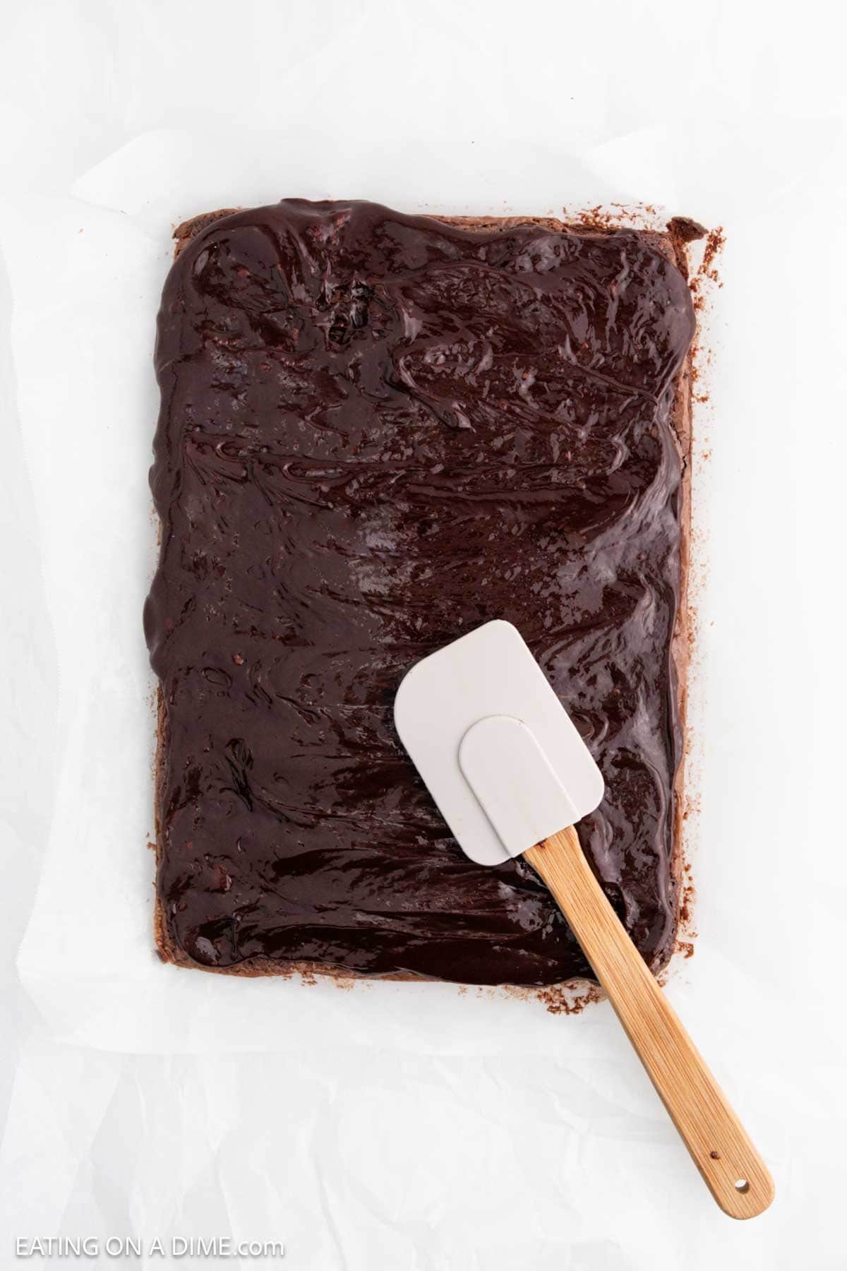Ganache poured over the brownies with a spatula