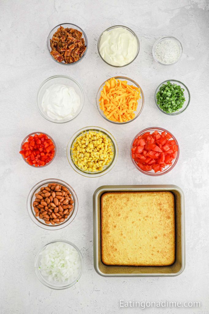 Ingredients needed - cornbread, onion, bell pepper, tomatoes, sweet corn, beans, cheese, bacon, green onions, mayonnaise, sour cream, ranch dressing mix