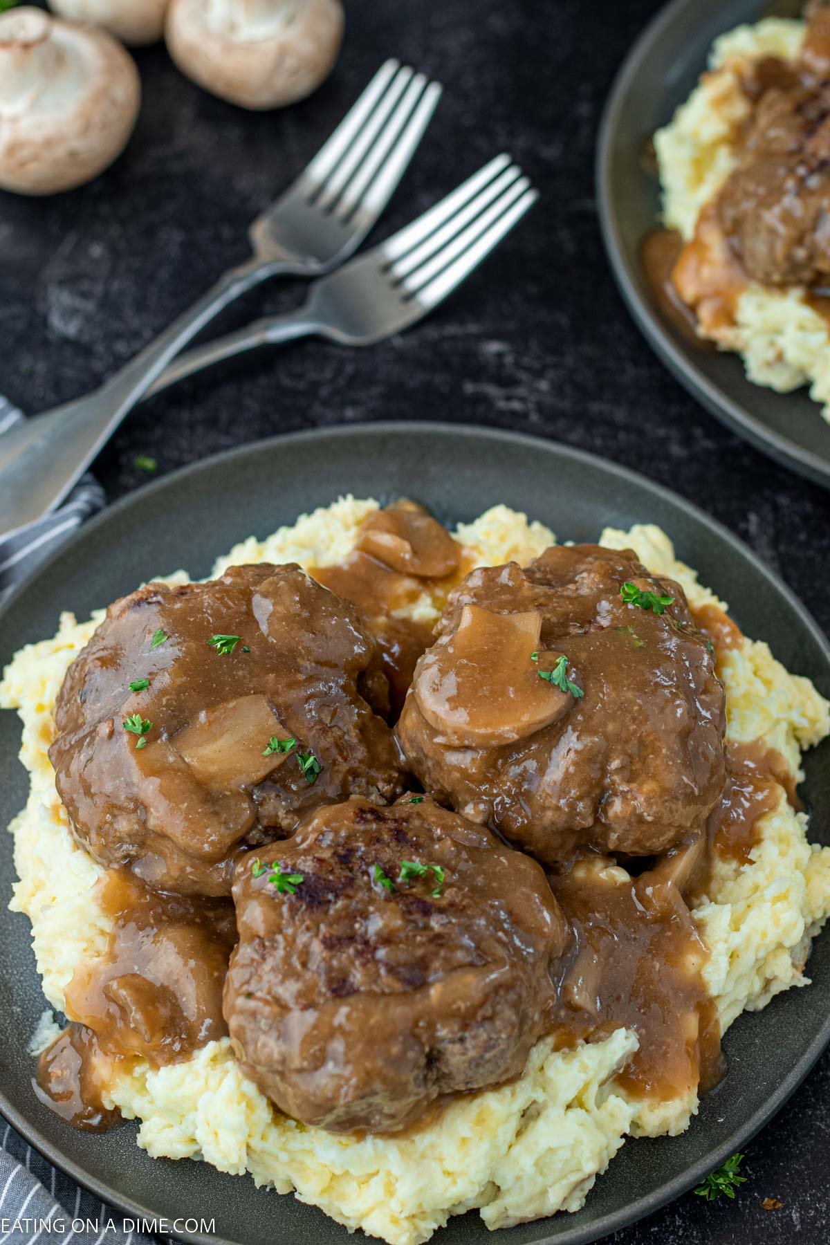 Salisbury Steak over mashed potatoes on a plate