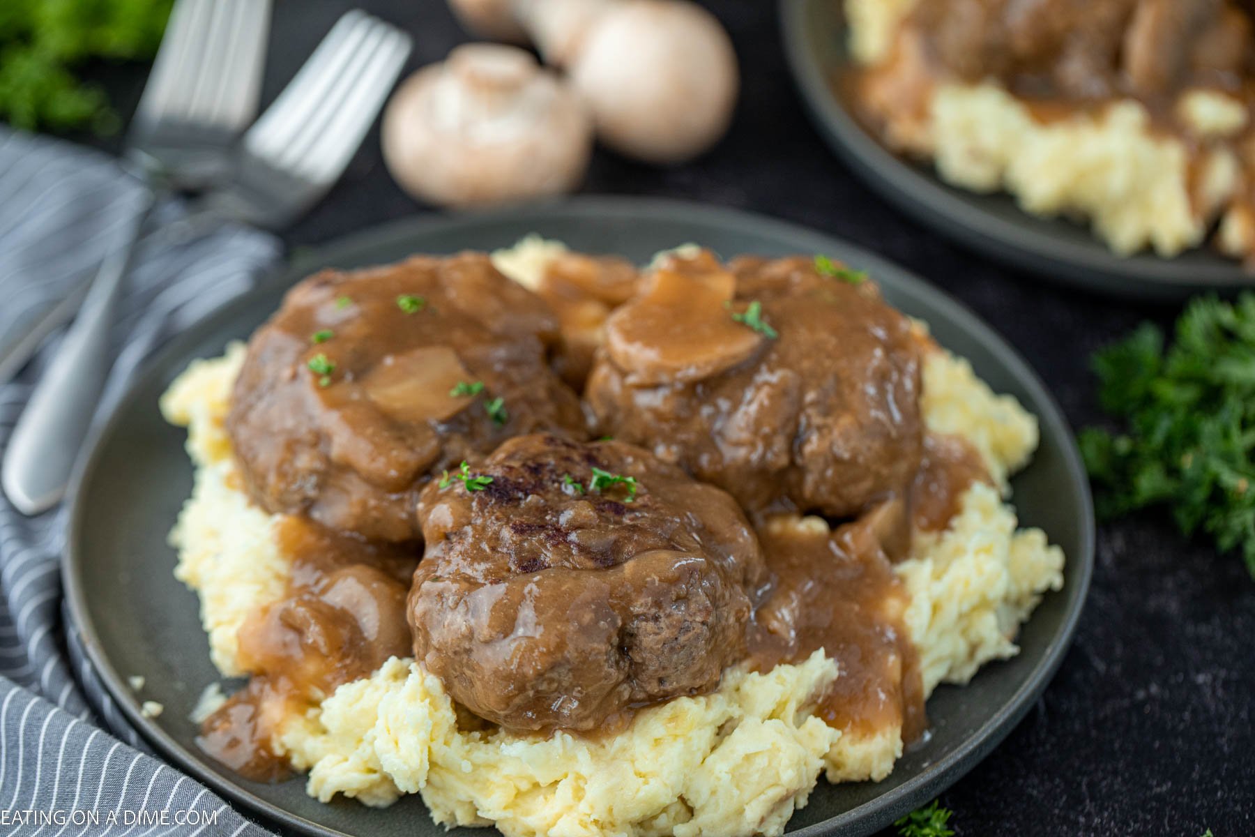 Salisbury Steak over mashed potatoes on a plate