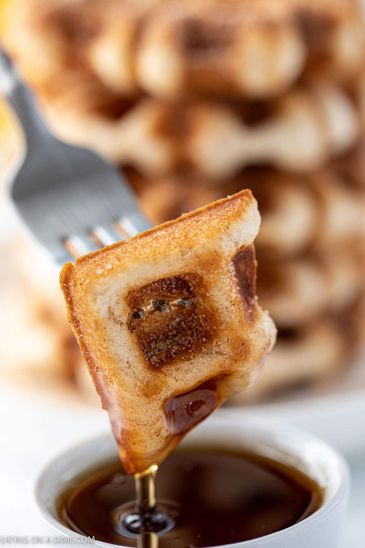 A bite of cinnamon and sugar waffle on a fork