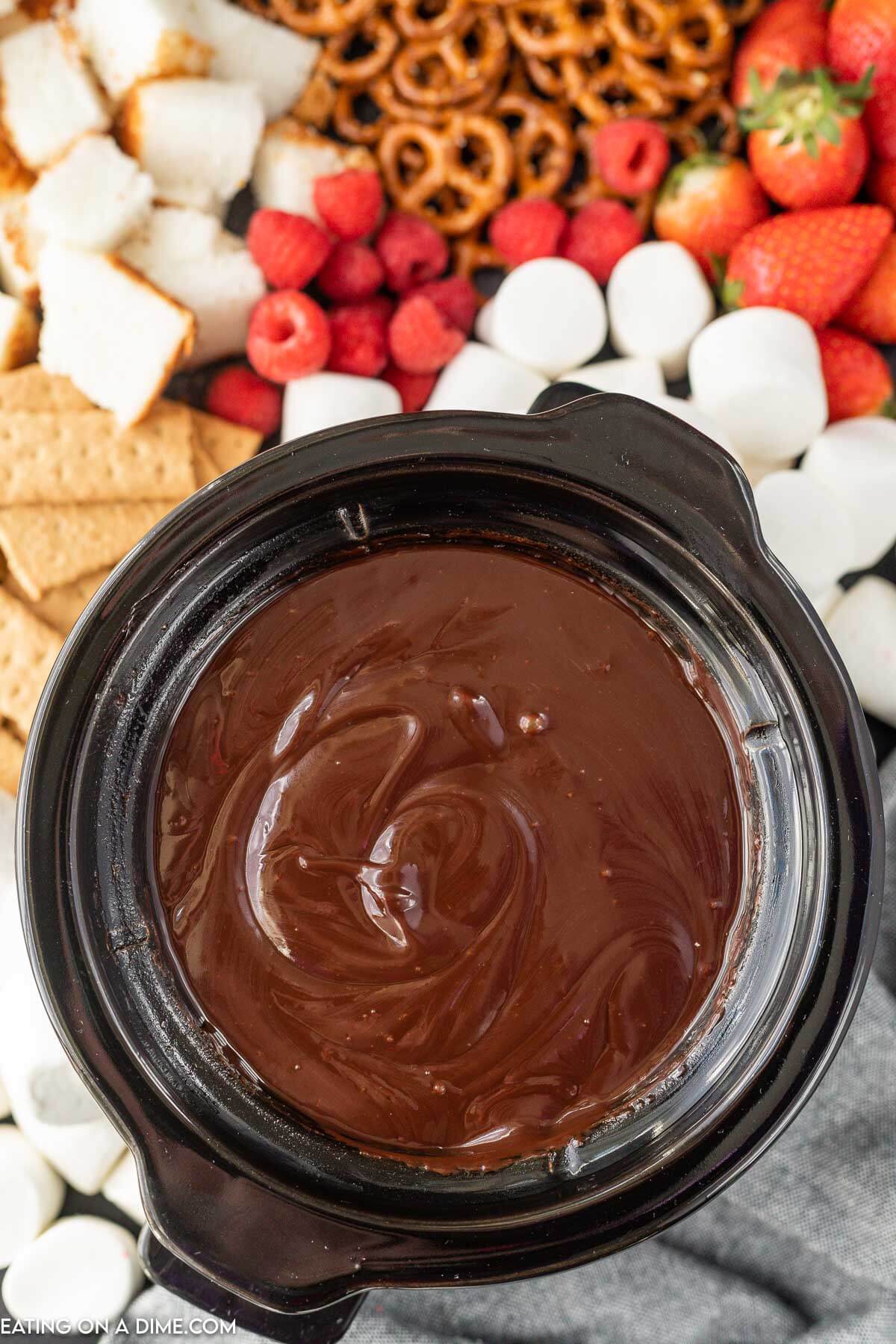 Melted chocolate in the crock pot a side of strawberries, graham crackers and marshmallows