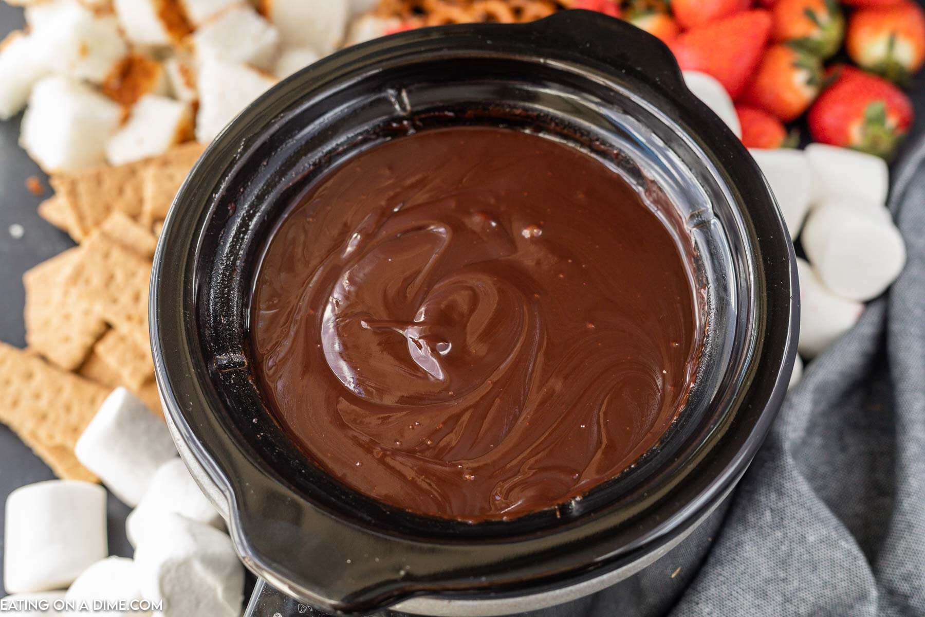 Melted chocolate in the crock pot a side of strawberries, graham crackers and marshmallows