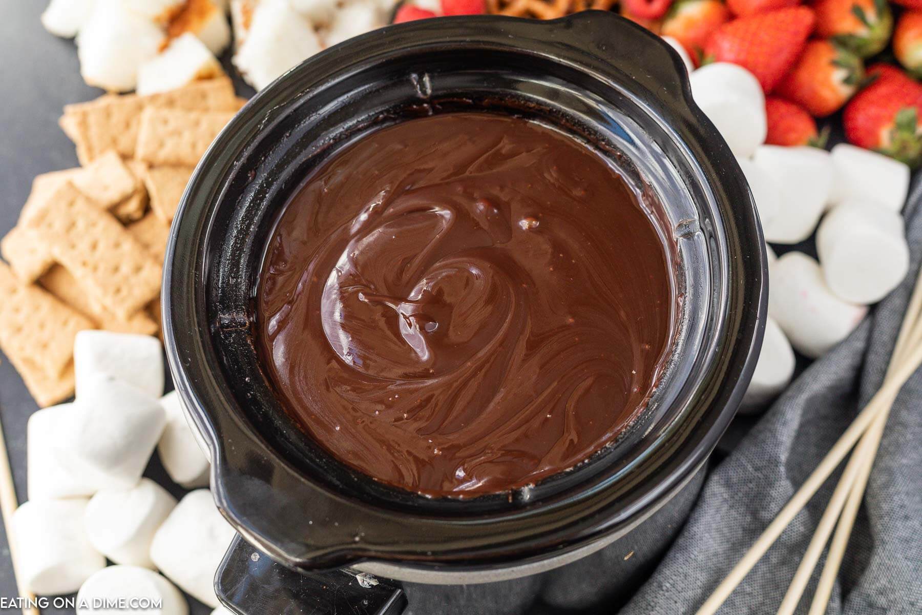 Melted chocolate in the crock pot a side of strawberries, graham crackers and marshmallows