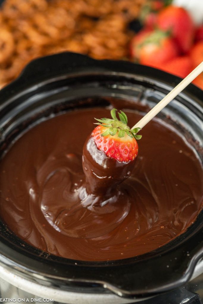 Melted Chocolate in a slow cooker and dipping strawberry in it