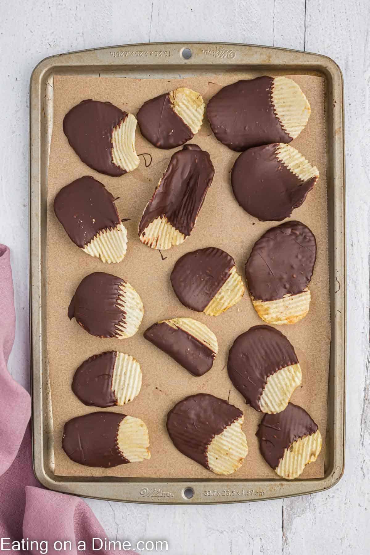 Chocolate dip potato chips on a baking sheet