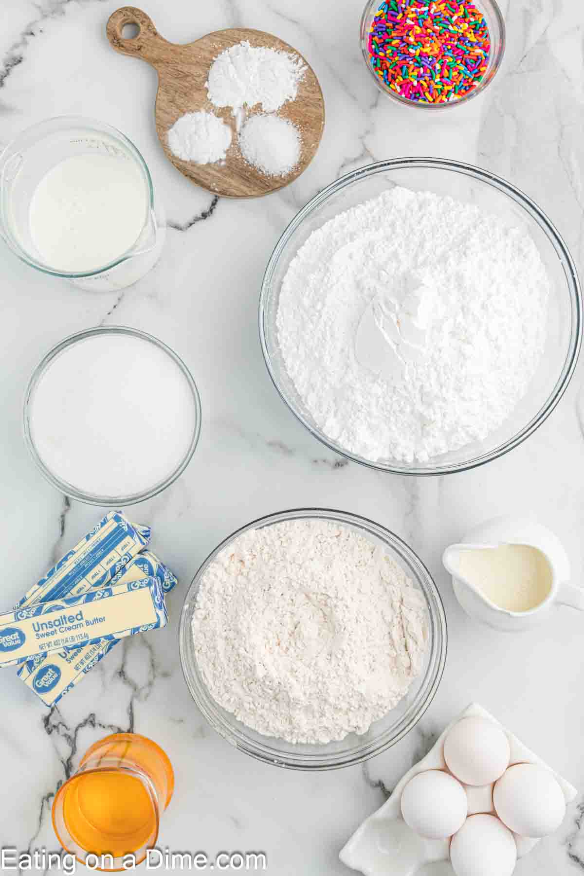 Ingredients needed - flour, baking powder, baking soda, salt, eggs, sugar, vanilla extract, oil, buttermilk, sprinkles, butter, powdered sugar, heavy cream