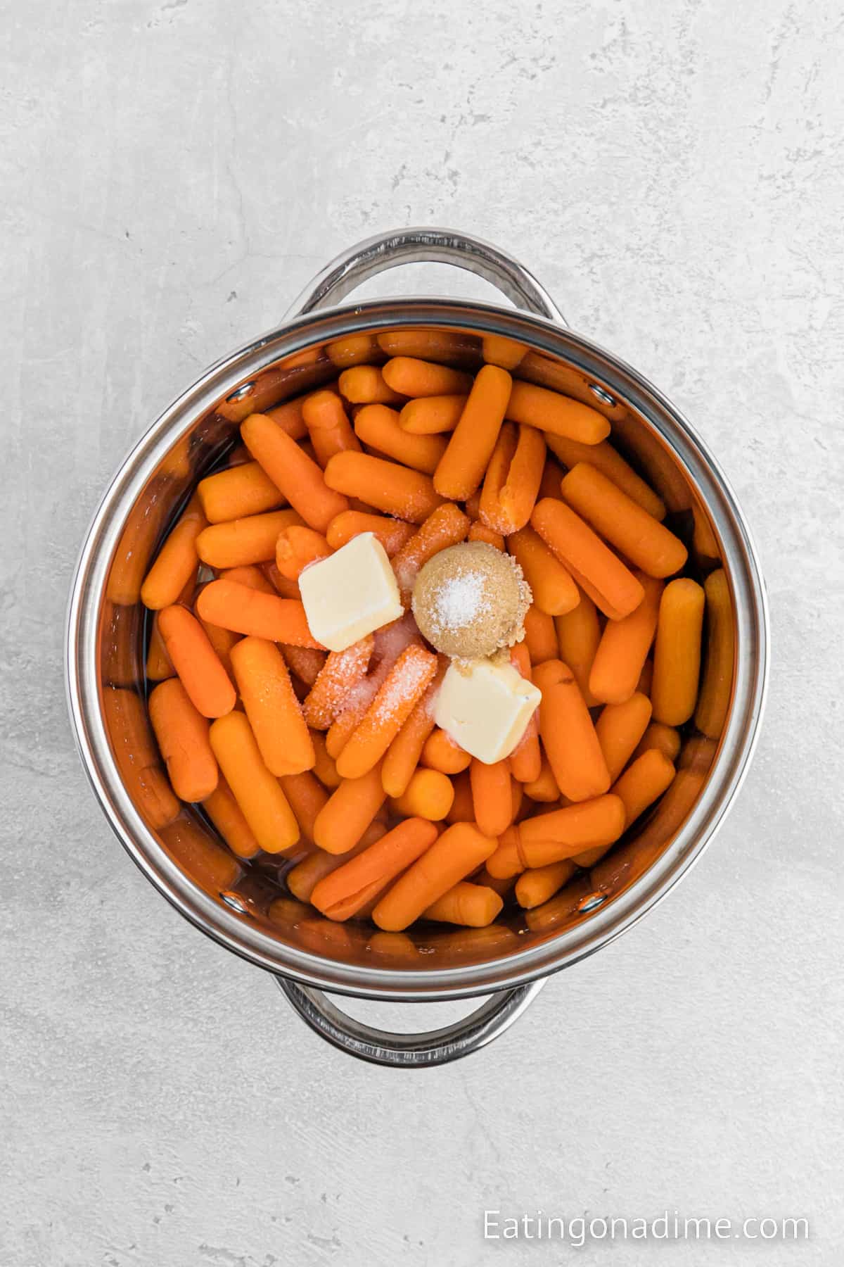 Baby Carrots in a large pot of water with slices of butter, salt and brown sugar