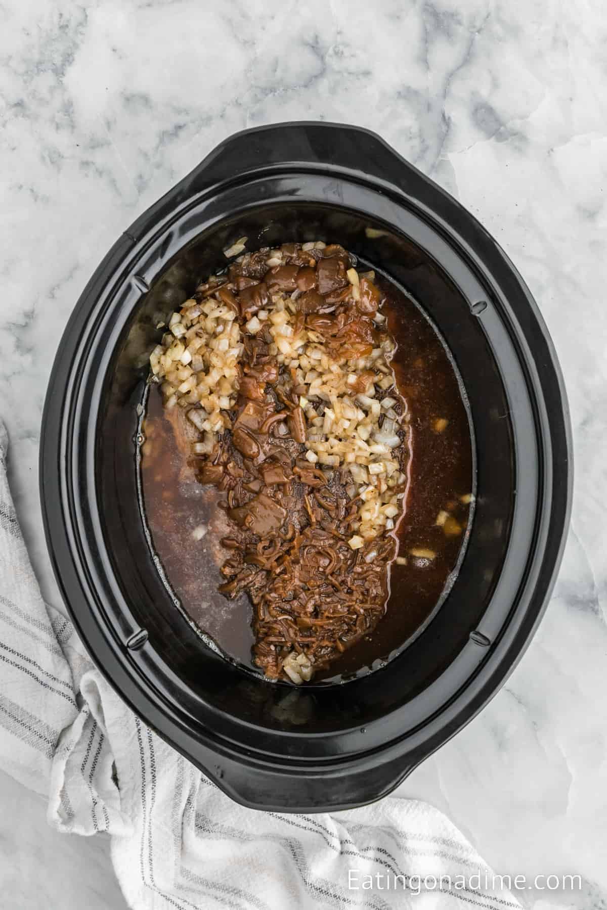 Cooked roast in the slow cooker and chopped onions