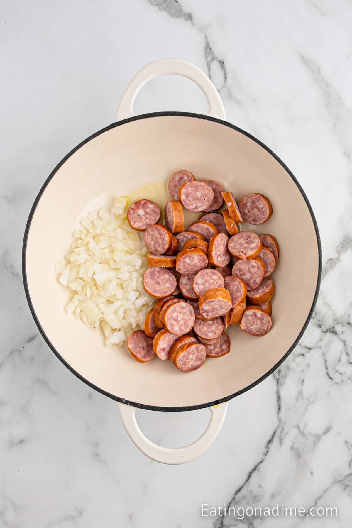 Slice kielbasa in a large pot with diced onions