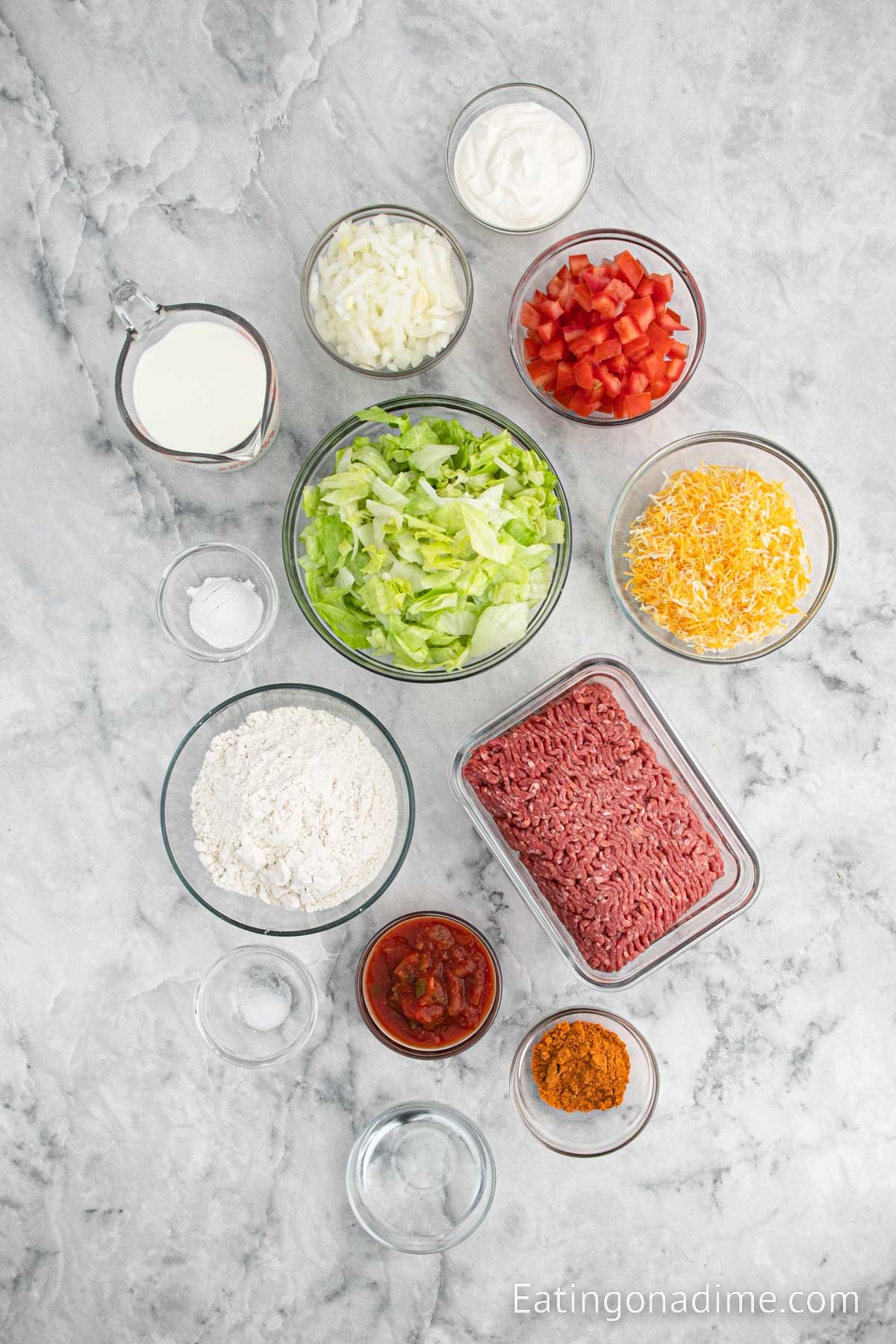 Ingredients needed for Chalupa Supreme - flour, baking powder, salt, vegetable oil, milk, ground beef, onion, taco seasoning, salsa, water, sour cream, lettuce, shredded cheese, tomatoes