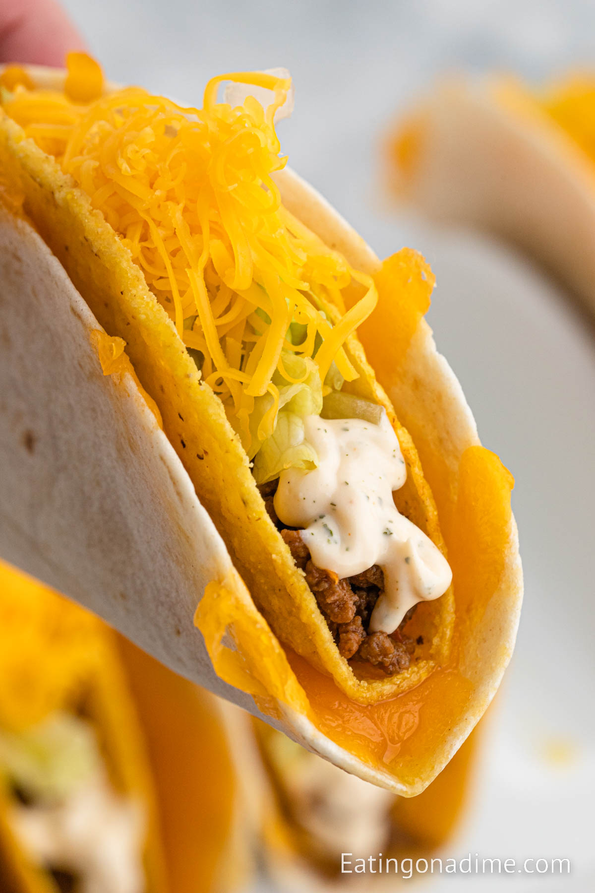 Taco Bell Cheesy Gordita Crunch being held close up