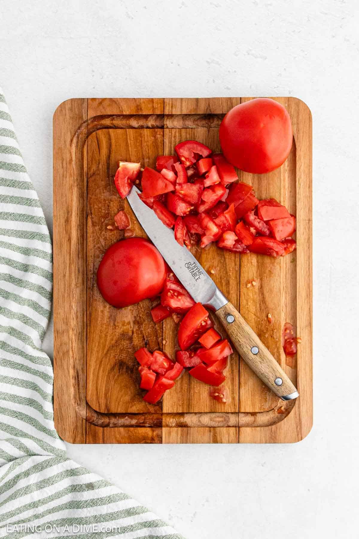 Chopped tomatoes on a cutting board with a sharp knife