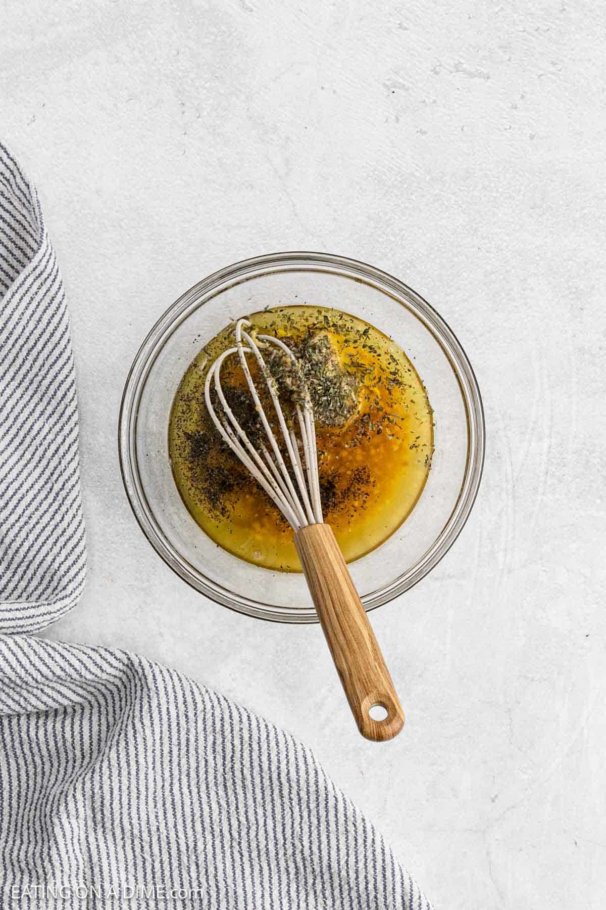 Combining the marinade ingredients together in a bowl with a whisk.