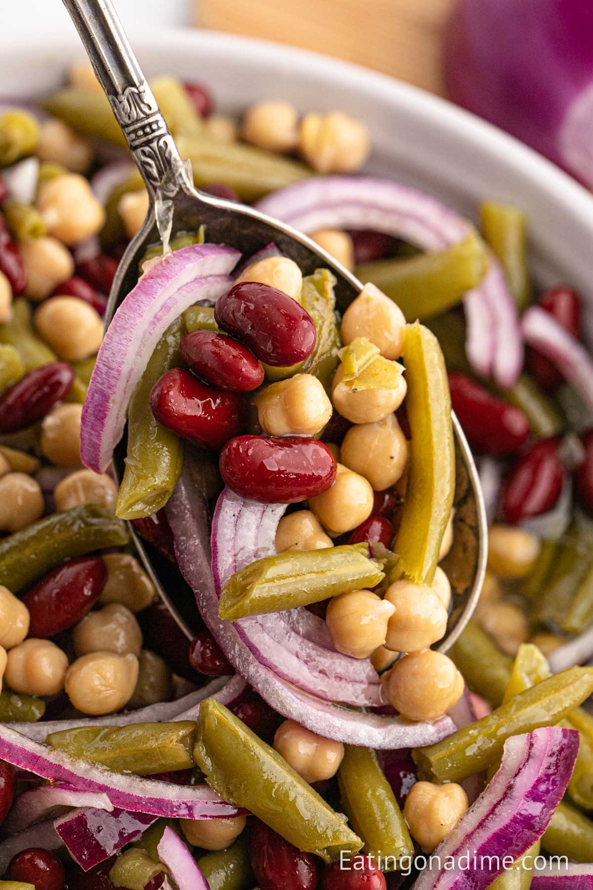 3 bean salad in a bowl with a bite on a spoon