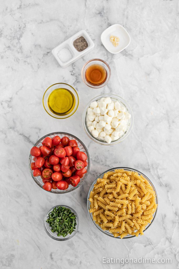 Ingredients needed - rotini pasta, mozzarella pearls, cherry tomatoes, basil, olive oil, balsamic vinegar, minced garlic, salt and pepper