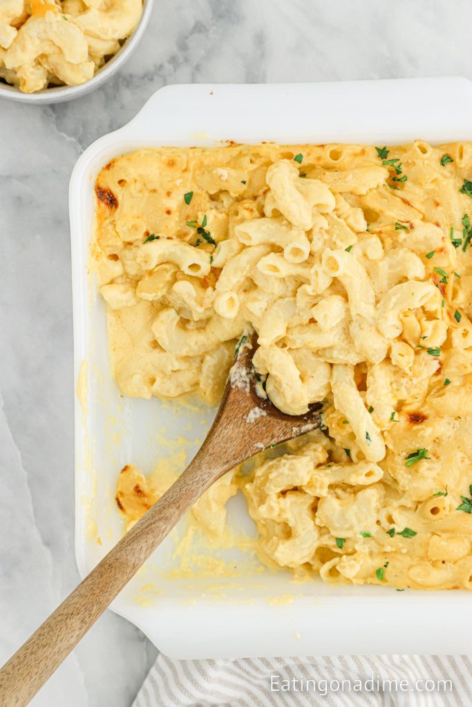 Mac and Cheese in a baking dish with a wooden spoon