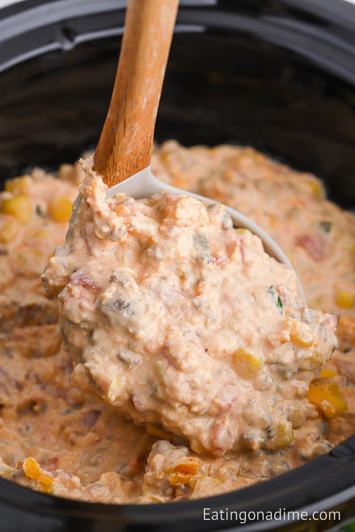 Cowboy Crack Dip in the slow cooker with a serving on a ladle