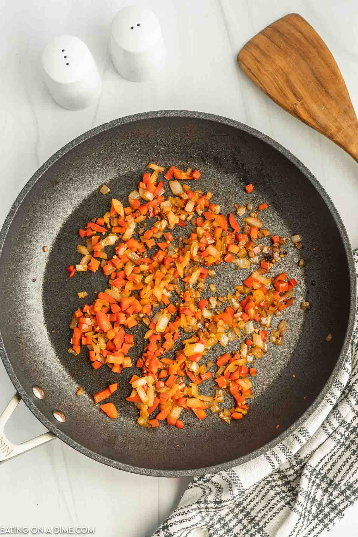 cooking onions and peppers in a skillet
