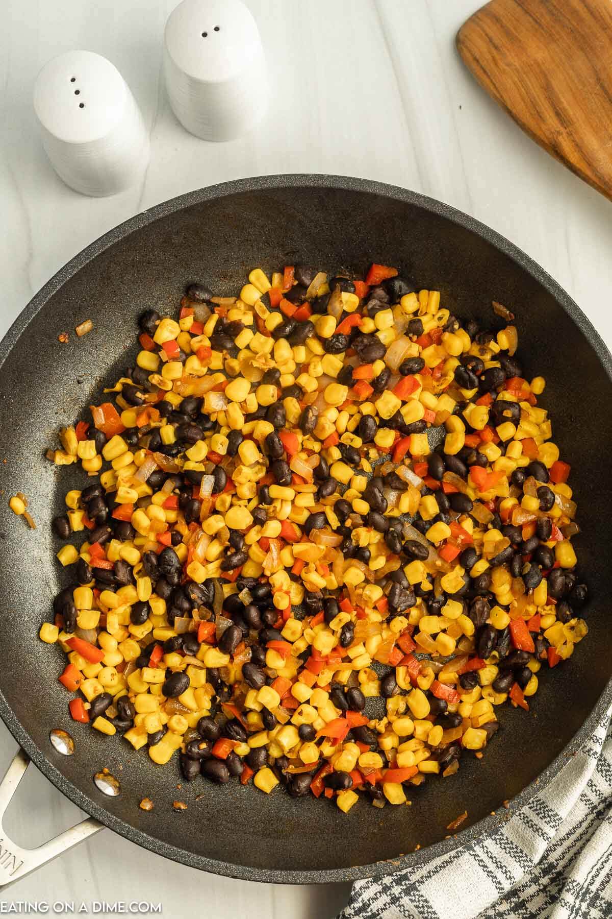 heating corn and black beans in a skillet