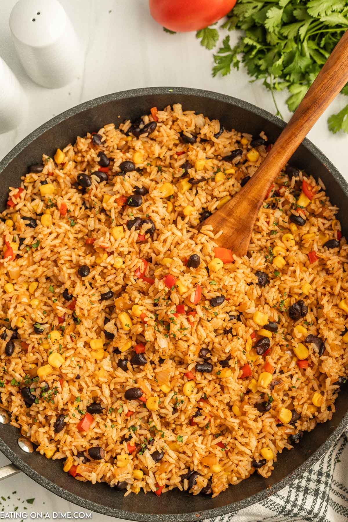 Mexican Fried Rice in a skillet with a wooden spoon