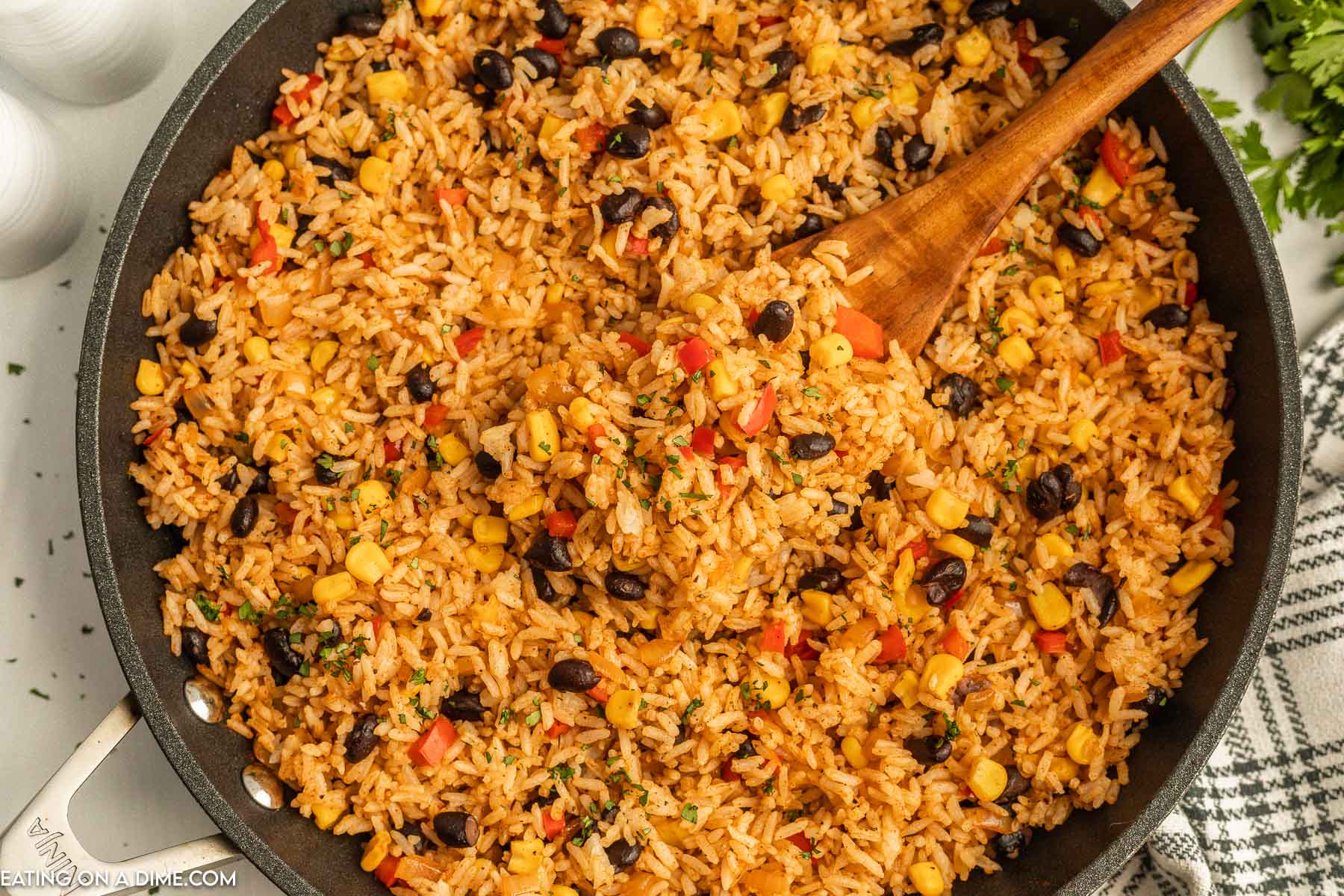 Mexican Fried Rice in a skillet with a wooden spoon