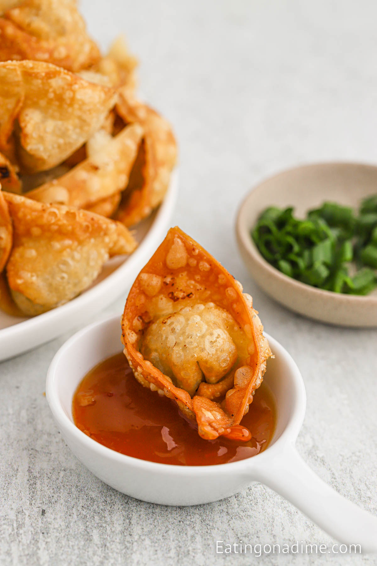 Fried wonton dipping into a sauce