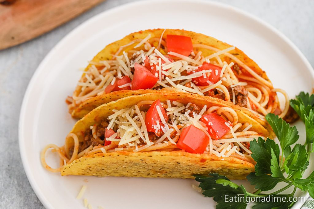 Two spaghetti tacos on a plate