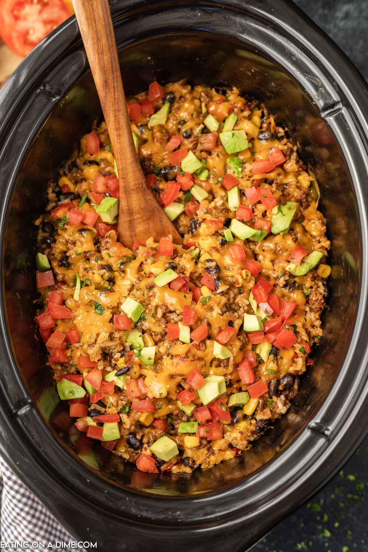 Taco Casserole in a slow cooker with a wooden spoon