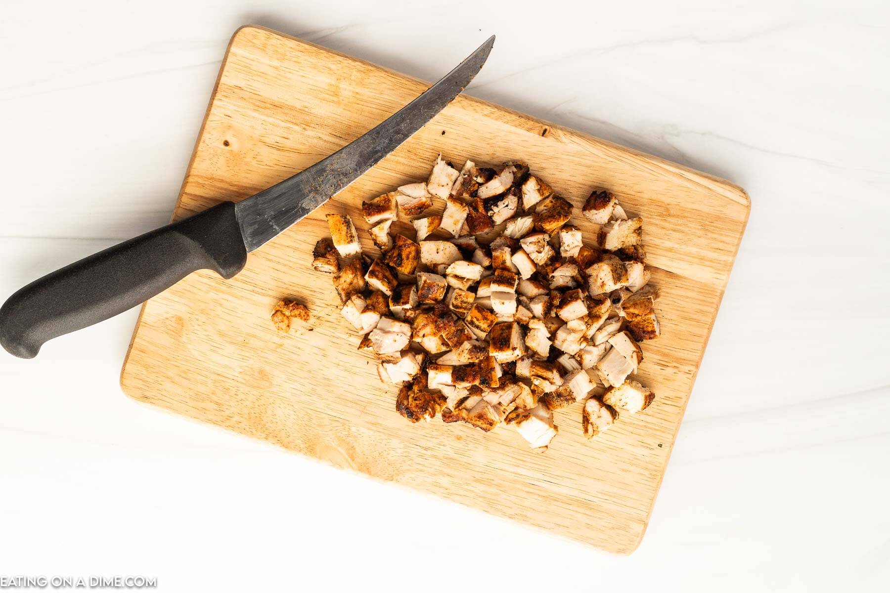 Diced chicken on cutting board. 