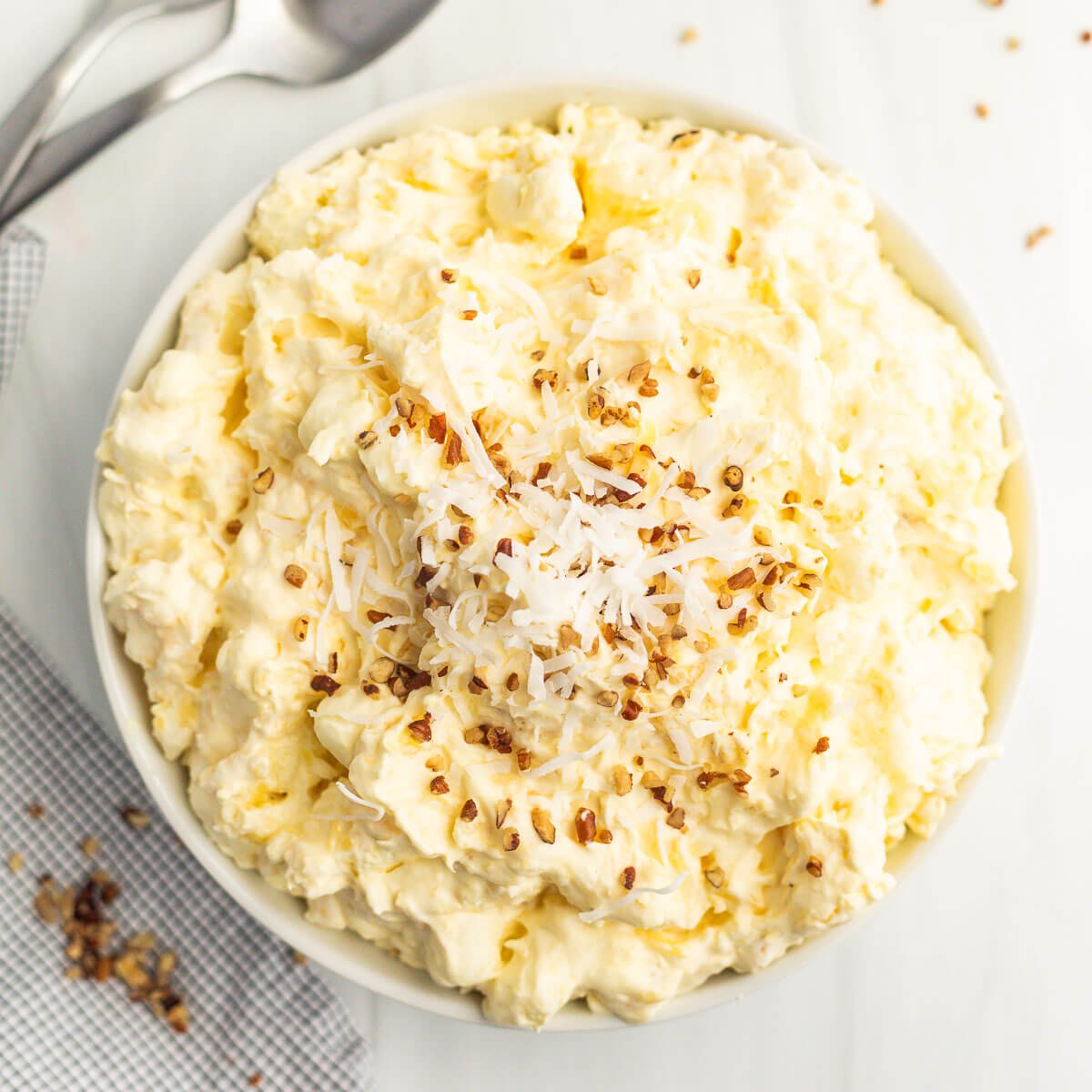 Pineapple Fluff Salad topped with chopped nuts in a bowl