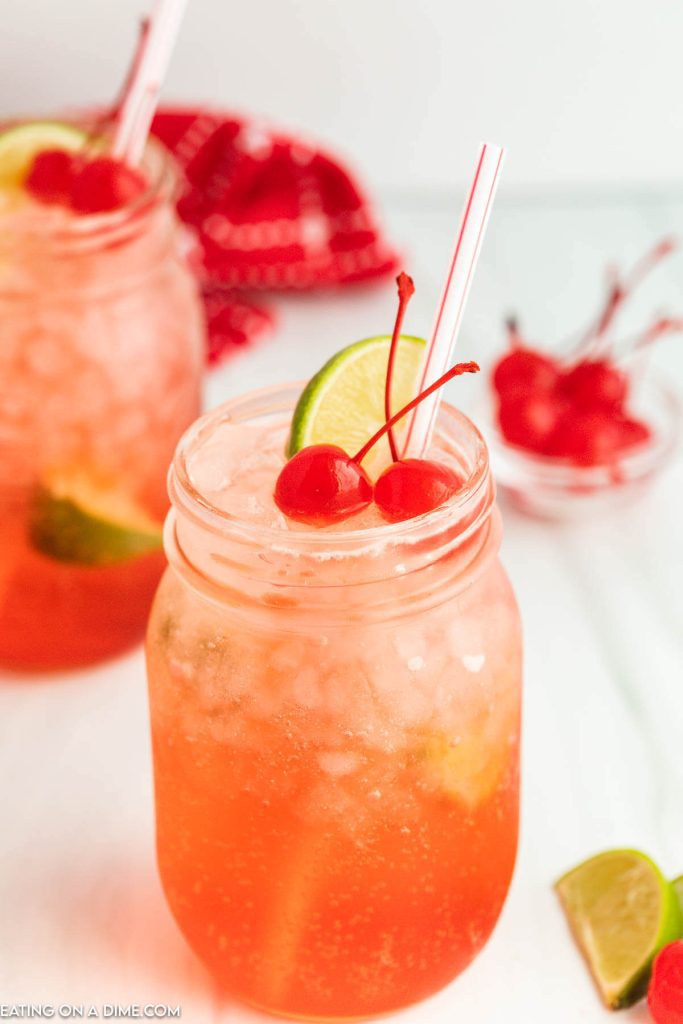 Cherry Limeade in a mason jar topped with cherries and lime wedges