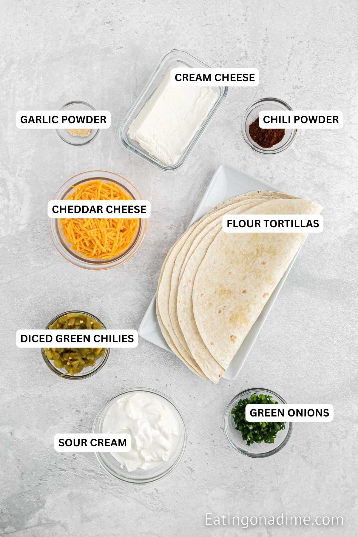 Ingredients for recipe: green onions, sour cream, diced green chilies, flour tortillas, cheddar cheese, chili powder, cream cheese and garlic powder.