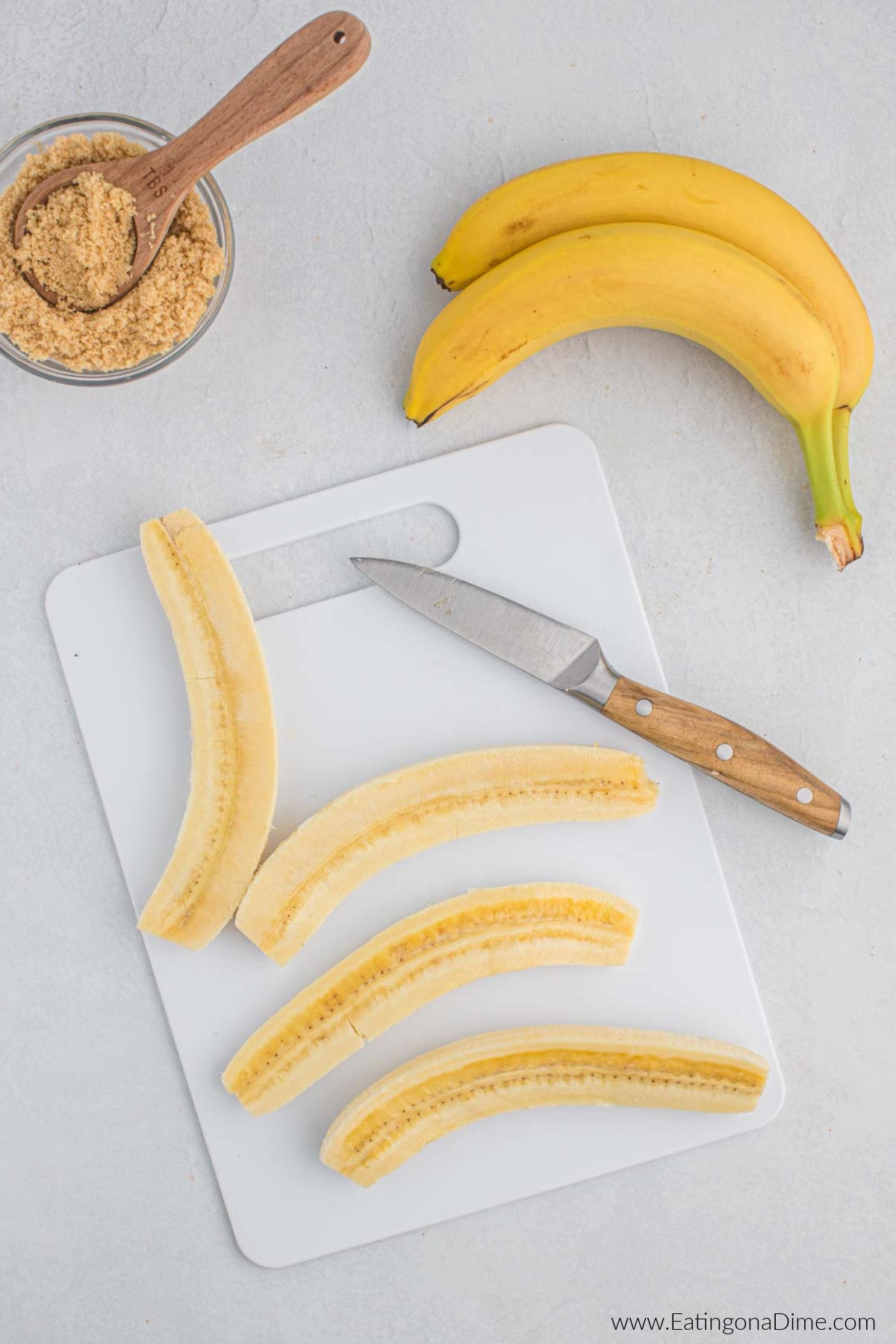 Peeled and sliced bananas on a cutting board.