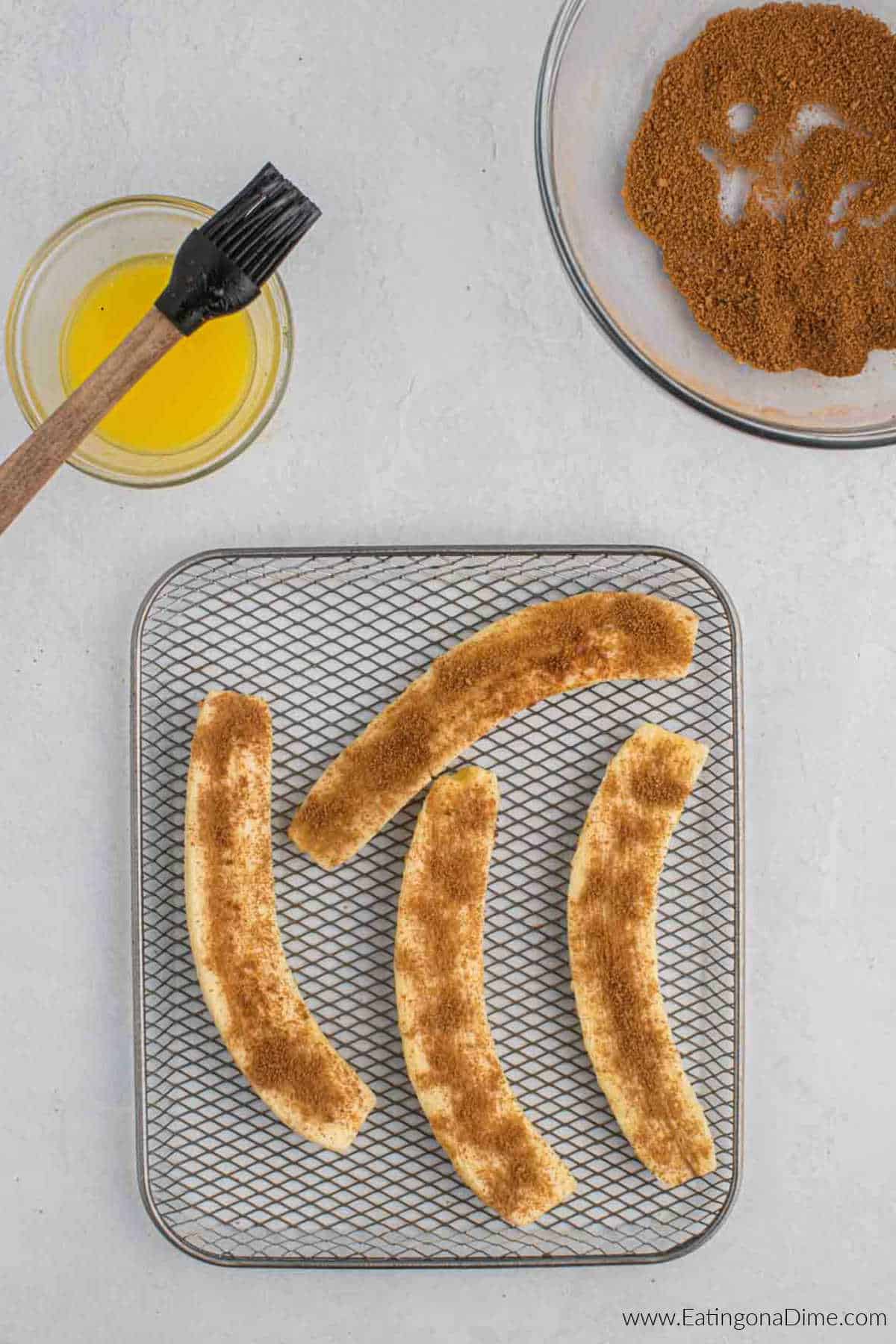 Cinnamon topped bananas placed on a air fryer basket.