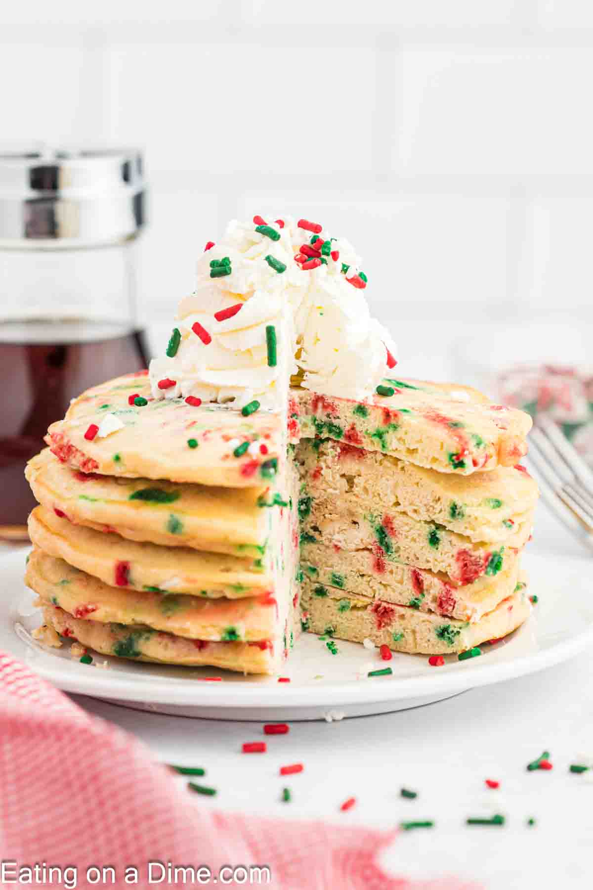 Christmas Sprinkles stacked on a plate topped with whipped cream and sprinkles