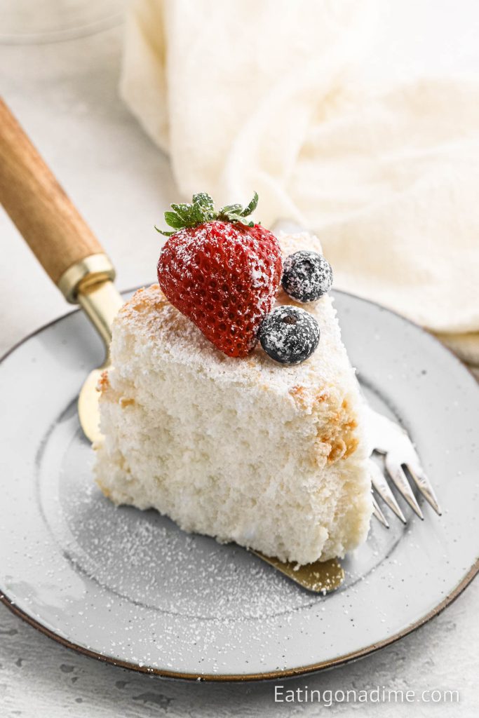 Slice of Angel Food Cake on a plate topped with berries