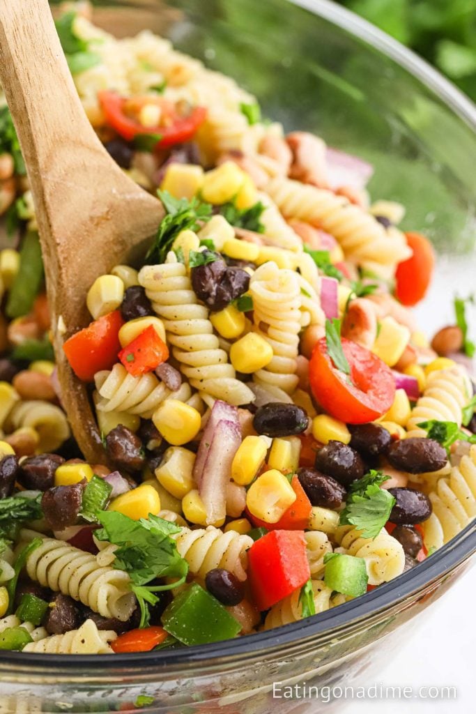Cowboy Caviar Pasta Salad in a bowl with a serving on a wooden spoon
