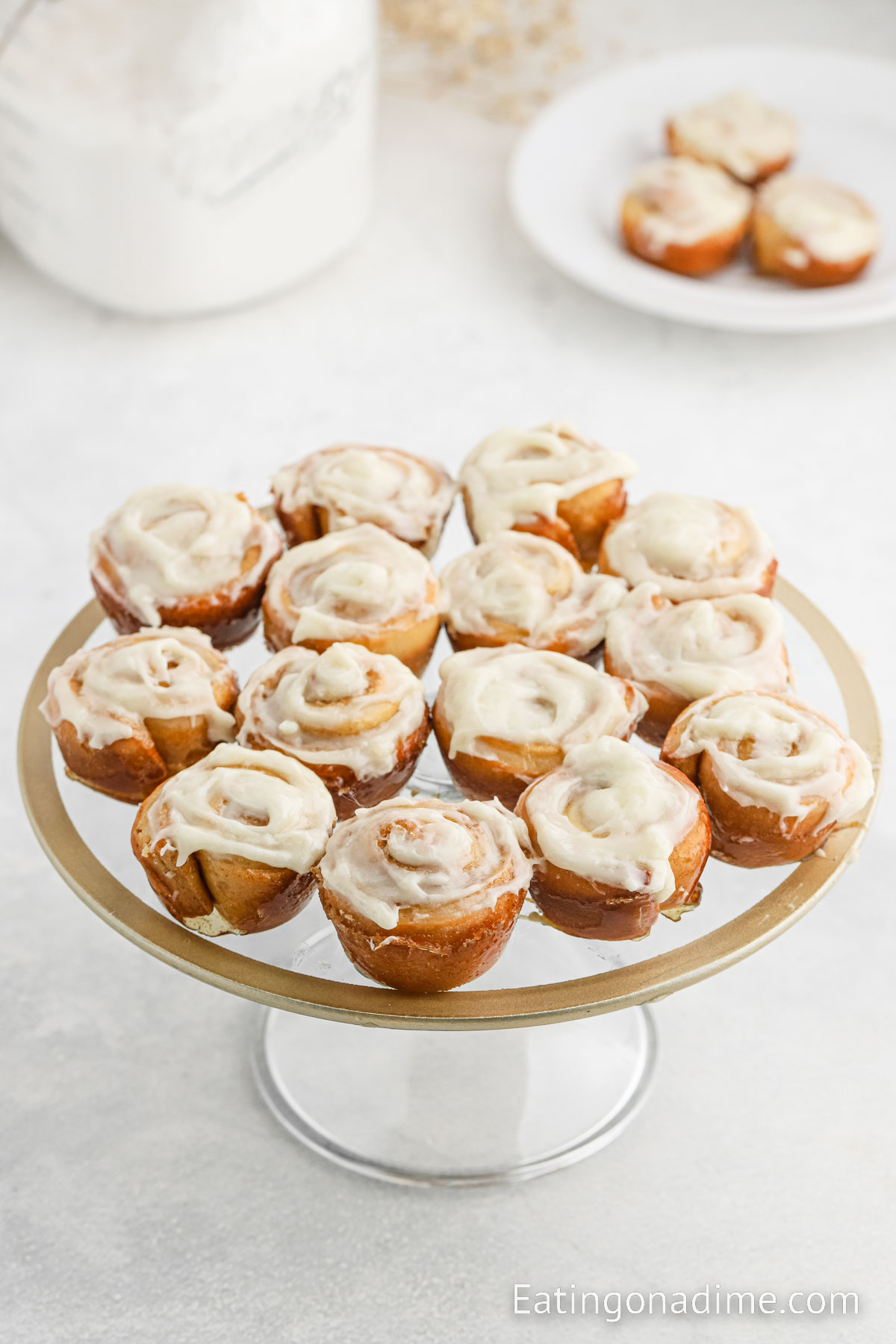 close up image of mini cinnamon rolls on a cake stand