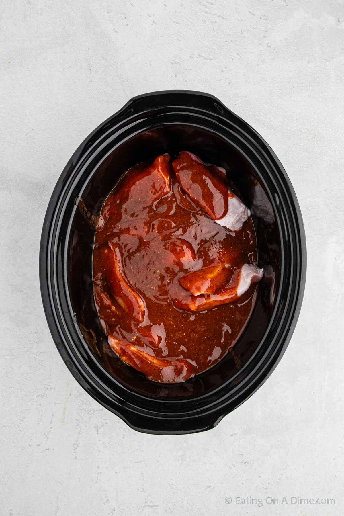 Sauce spread over the pork ribs in the slow cooker