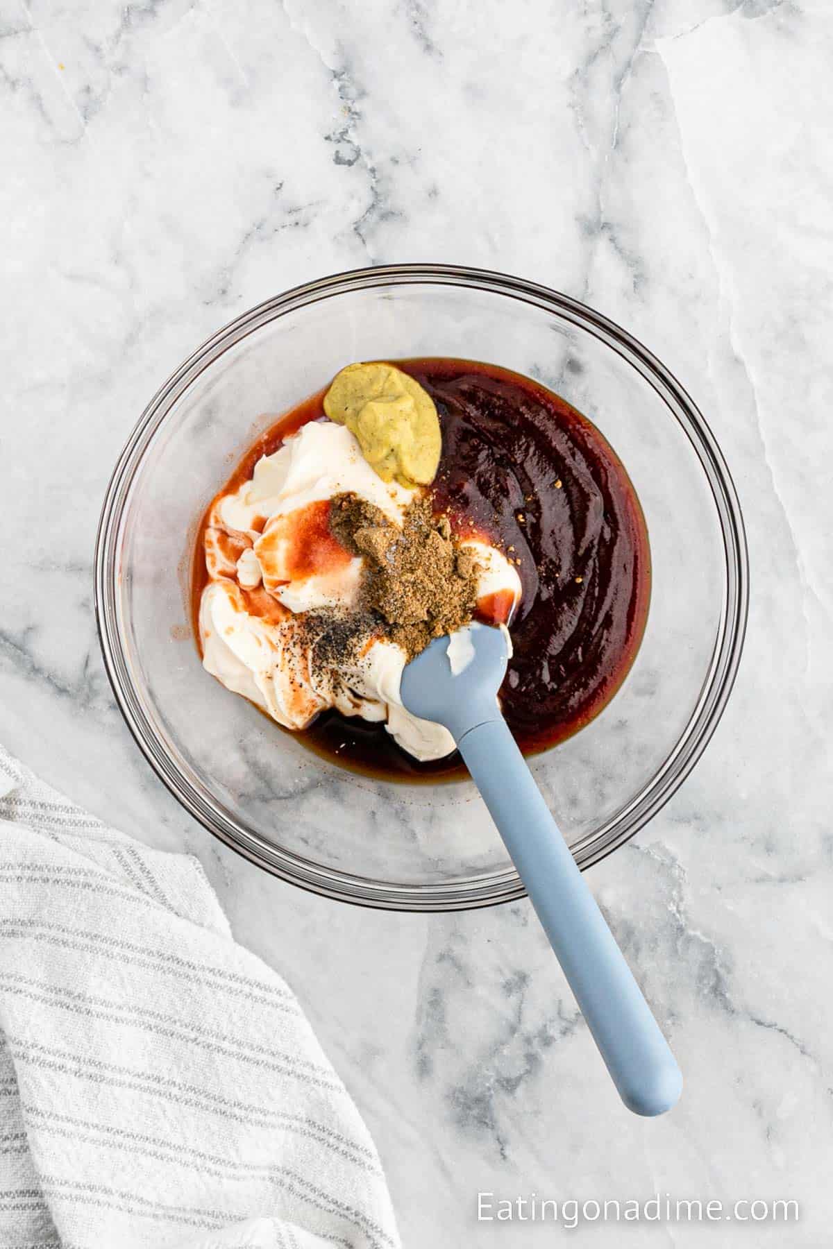 Combining dressing ingredients in a bowl with a spatula