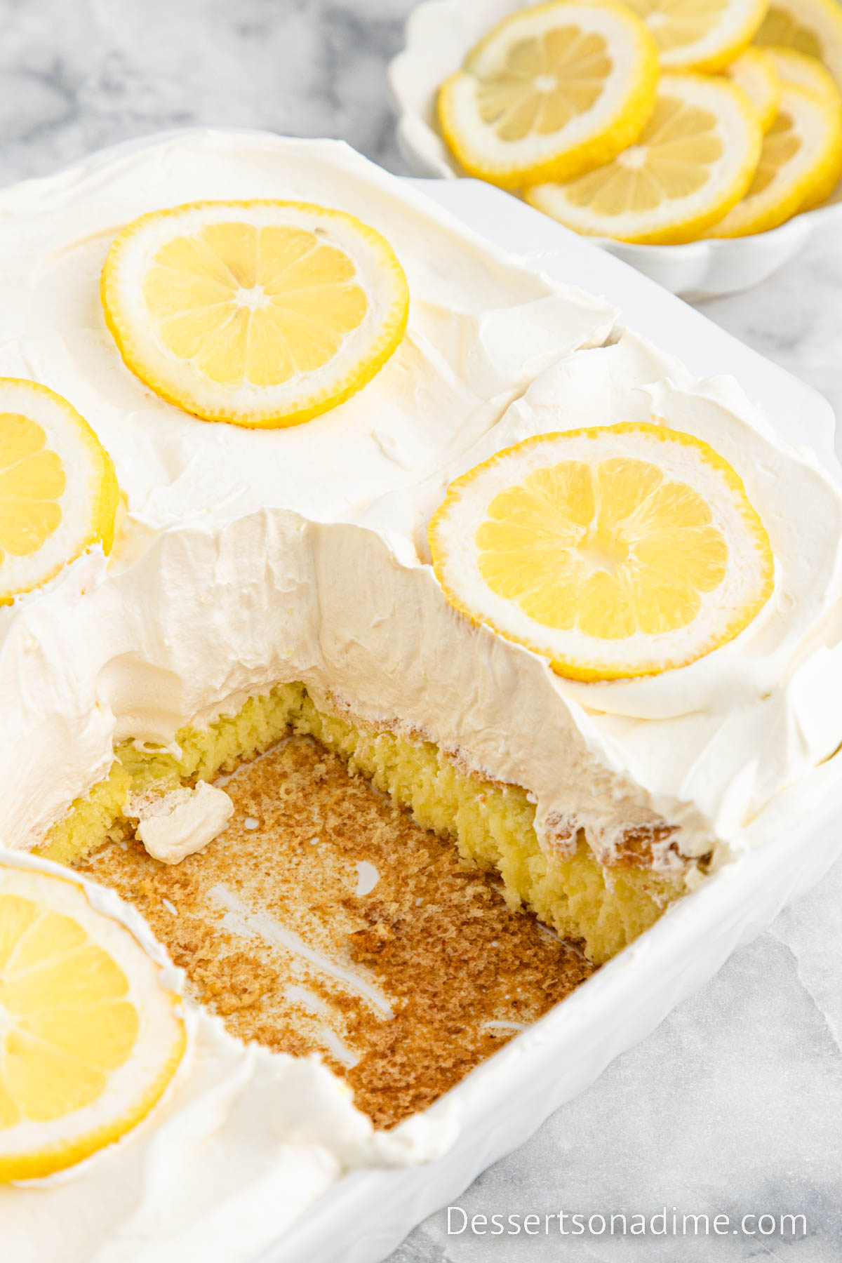 Lemon Angel Food Cake in a baking dish with a piece missing